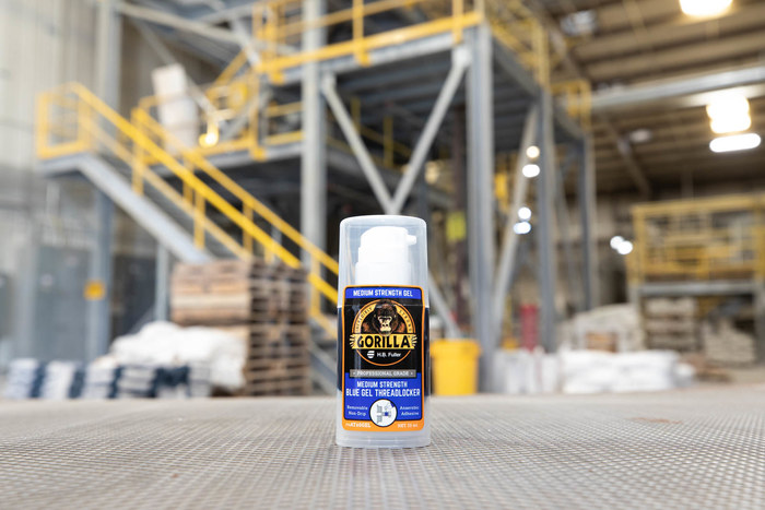 A photo of GorillaPro AT160 Gel threadlocker in the foreground, and an industrial warehouse in the background, out of focus. (Product image)