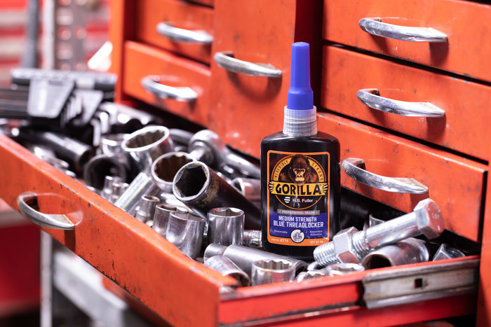 A photo of a bottle of GorillaPro AT75 blue medium strength threadlocker in a tool chest next to hand tools. (Product image)